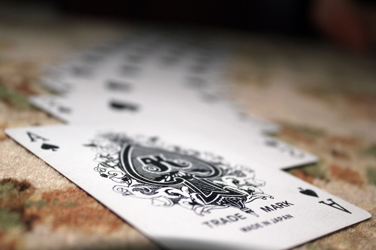 close up of ace of spades with a deck of playing cards showcasing dept