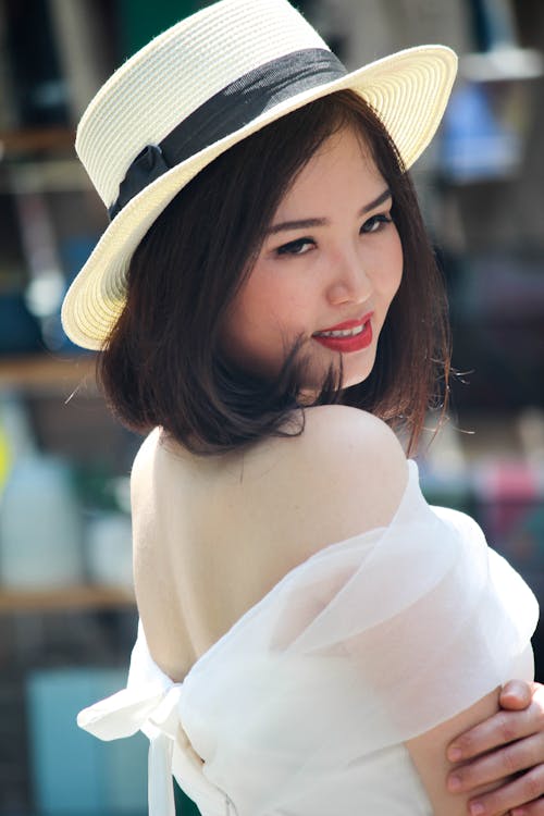 Gratis Wanita Dengan Topi Fedora Coklat Dan Gaun Off Shoulder Putih Foto Stok