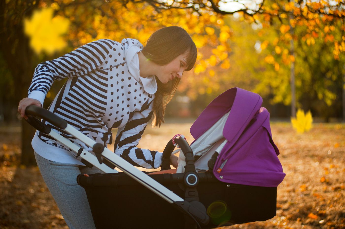 Parent walking outdoors with a baby stroller
