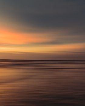 Peaceful ocean view with a vibrant sunset sky, perfect for calming backgrounds.