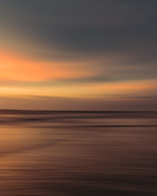 Free Peaceful ocean view with a vibrant sunset sky, perfect for calming backgrounds. Stock Photo