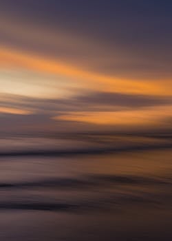 A beautiful abstract view of a sunset over the ocean with smooth, blurred waves.