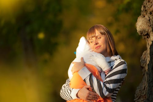무료 그녀의 아기를 들고 여자의 얕은 초점 사진 스톡 사진