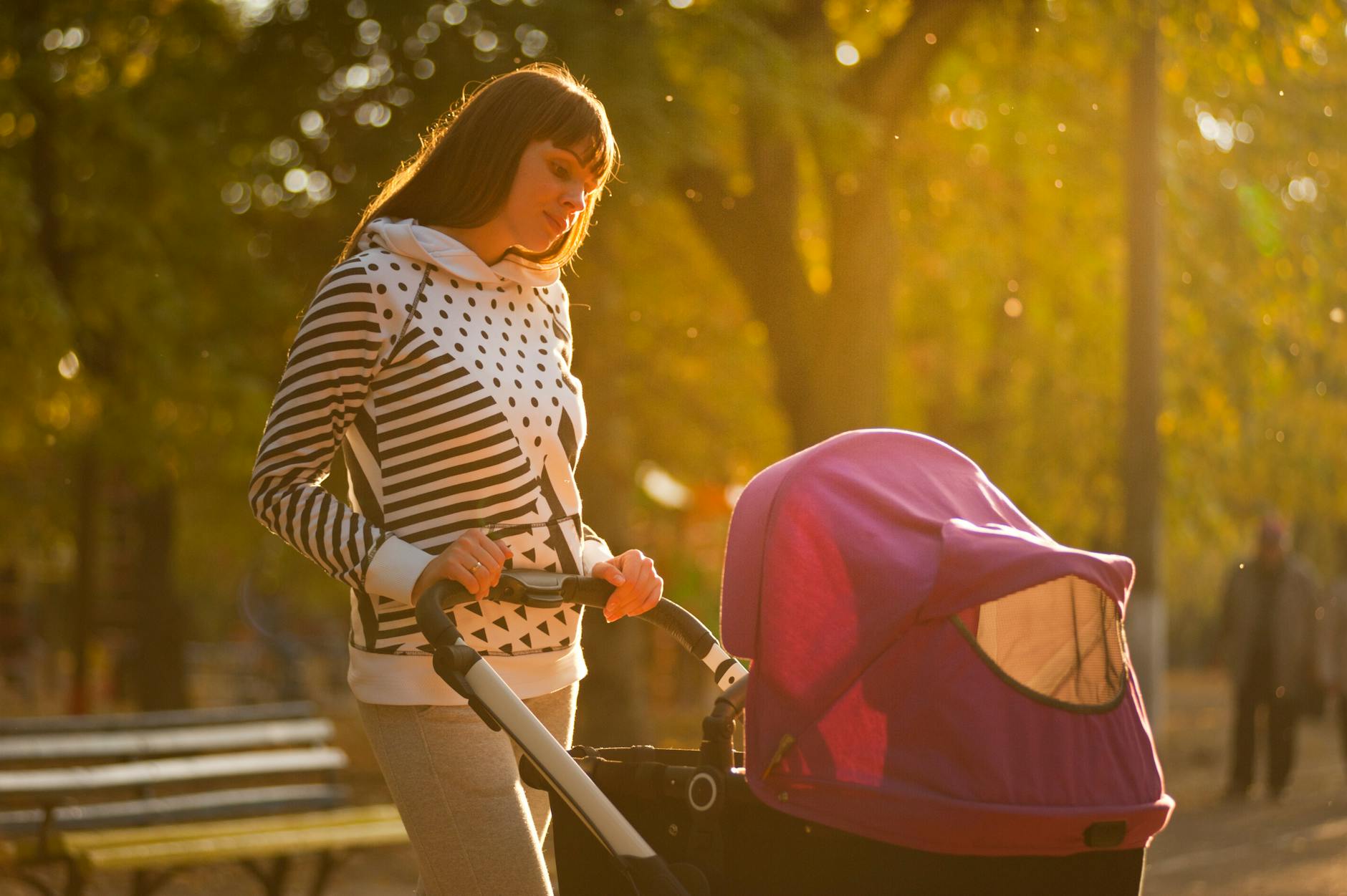 woman holding pink and black stroller