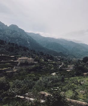 西班牙瓦尔德莫萨的宁静景观中，郁郁葱葱的绿色植物与雄伟的山脉交相辉映