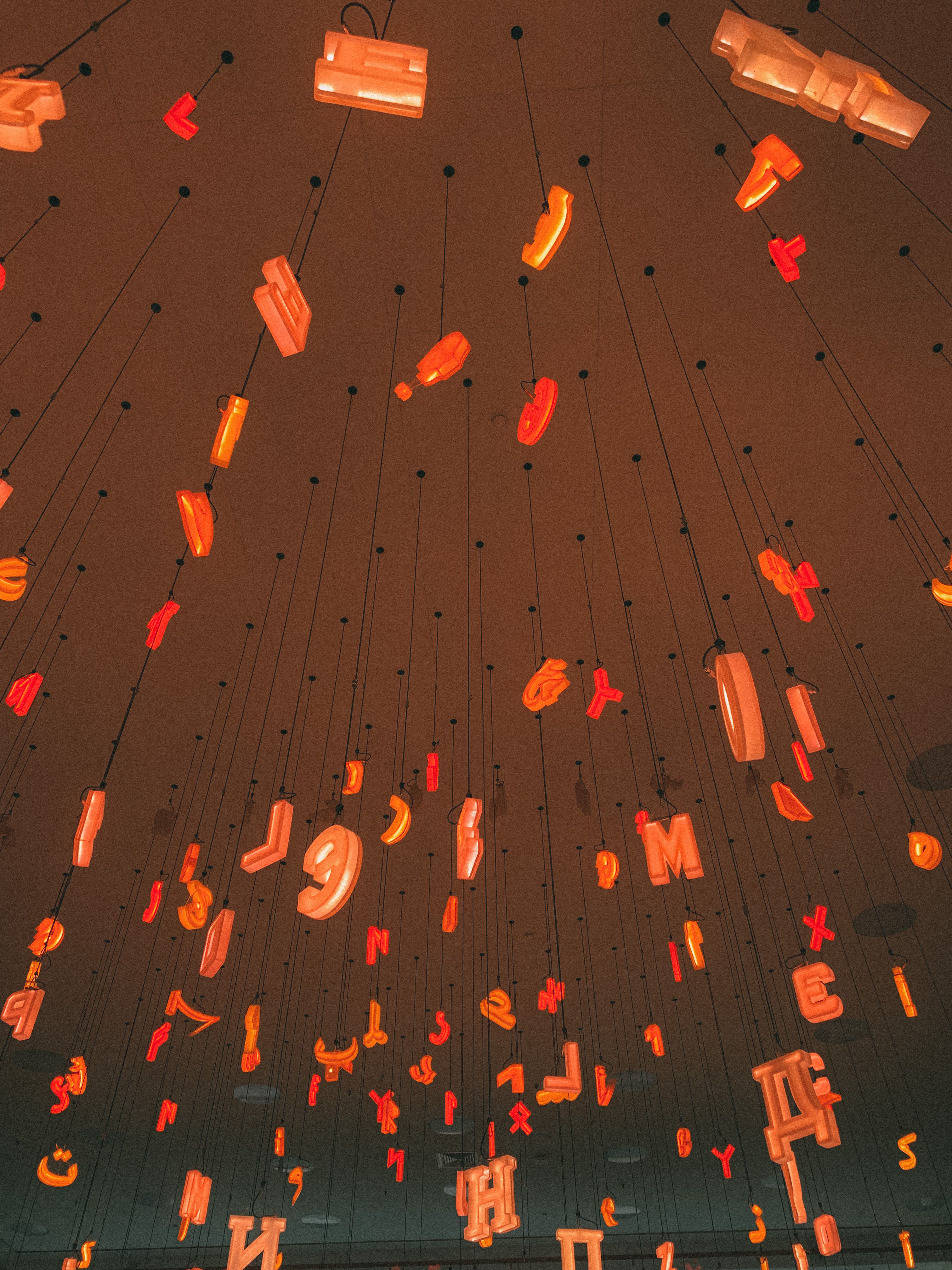 Ceiling display of glowing letters art installation with ambient lighting