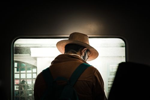 Free A man in a cowboy hat gazing out a train window in İstanbul, capturing a contemplative travel moment. Stock Photo