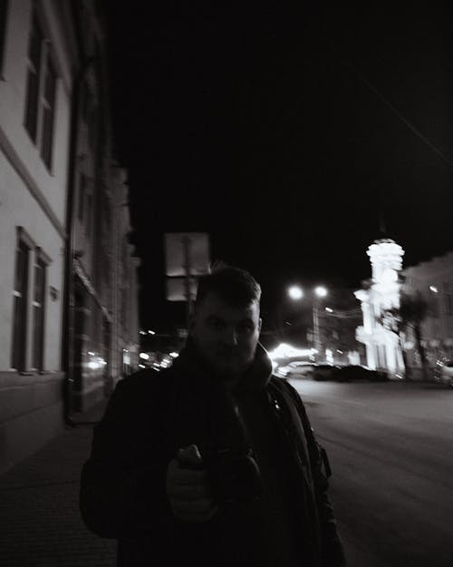 A Grayscale Photo of a Man in the Street