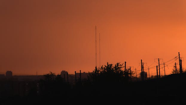 City silhouette with an orange sky backdrop at sunset, capturing urban tranquility.