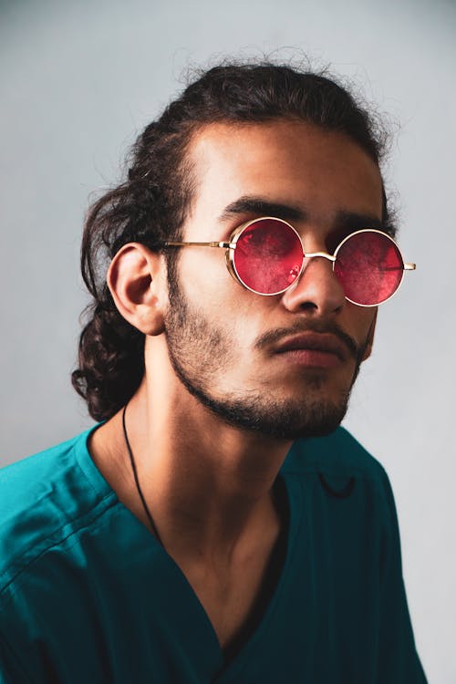 A Man in Blue Shirt Looking while Wearing Sunglasses