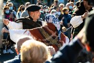 Vibrant outdoor festival with dancers in traditional attire performing during the day.