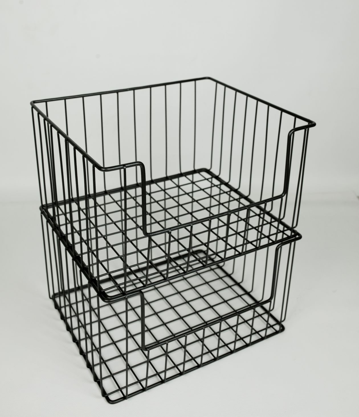 stackable black wire storage baskets on a white background