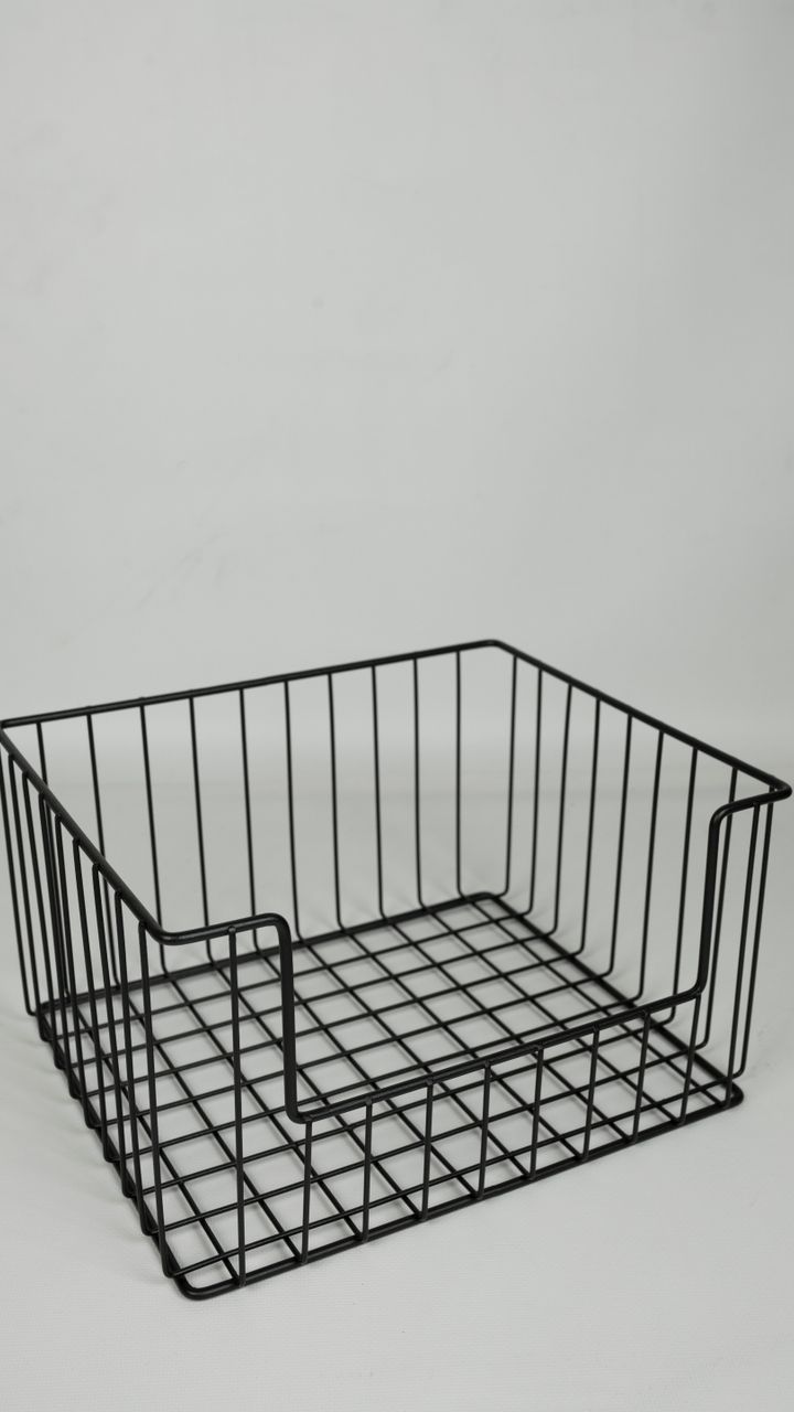 galvanized wire basket holding coffee pods and stir sticks next to a coffee maker