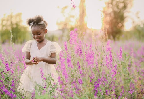 Little Girl Standing in Blooming Meadow