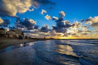 加沙的海滩日落令人惊叹，海浪起伏，天空多云，充满戏剧性