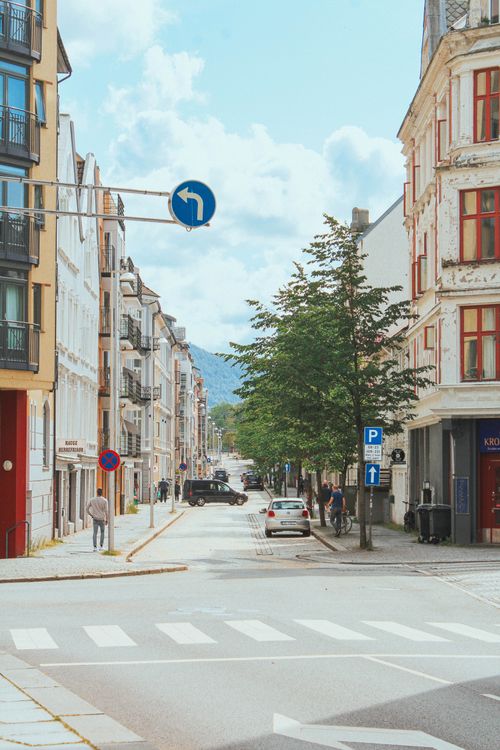 Free Scenic view of a vibrant street in Bergen, Norway with classic architecture and people strolling. Stock Photo