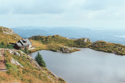 Serene landscape featuring a mountain lake and cabin near Bergen, Norway.