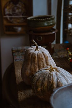 Warm autumn setting with rustic pumpkins on a wooden table, perfect for seasonal home decor.