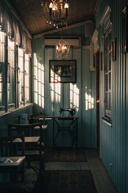 Charming cafe interior in Trondheim with a vintage sewing machine and elegant lighting.