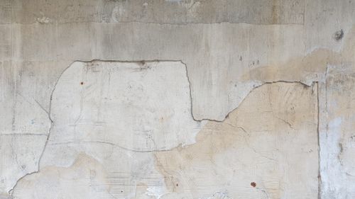 Free Close-up of a cracked, weathered concrete wall with visible textures and patterns. Stock Photo