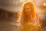 在阳光明媚、温暖的环境中，一位长发微笑女子的肖像