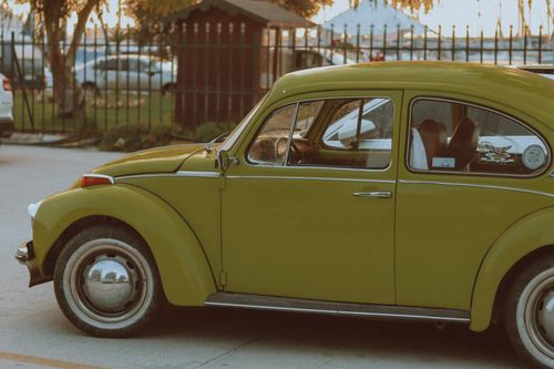 Free Vintage green Volkswagen Beetle parked outdoors in a city environment. Stock Photo