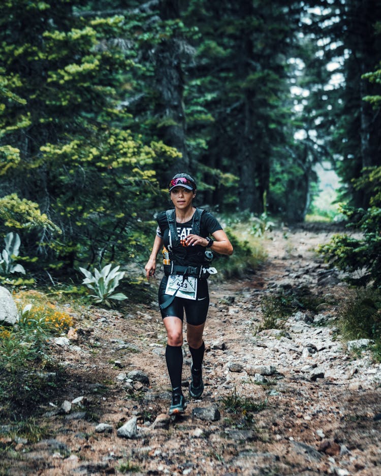 Woman Running Through A Forest 