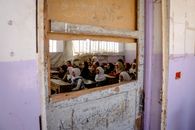 View on Girls in Class through Hole in Doors