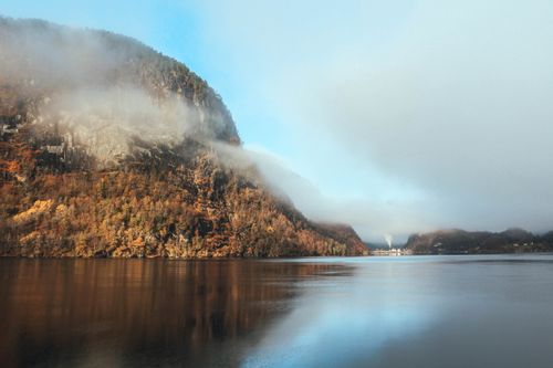 Free Serene view of a mist-covered fjord in Norway surrounded by autumn foliage, reflecting tranquility. Stock Photo