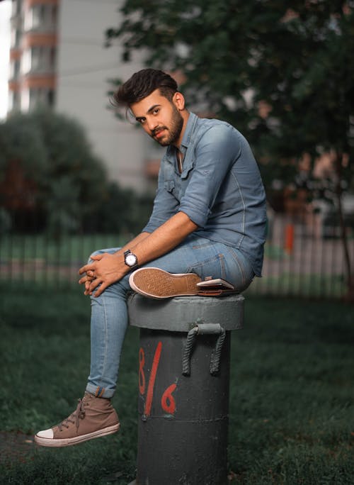 Stylish Man sitting on a Cylindrical Surface 