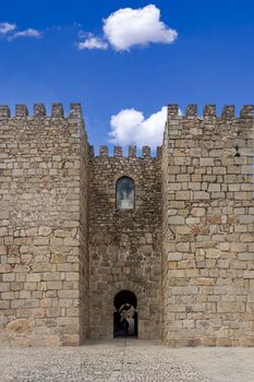 Historic stone fortress with gothic architecture in Trujillo, Spain under vibrant blue skies.