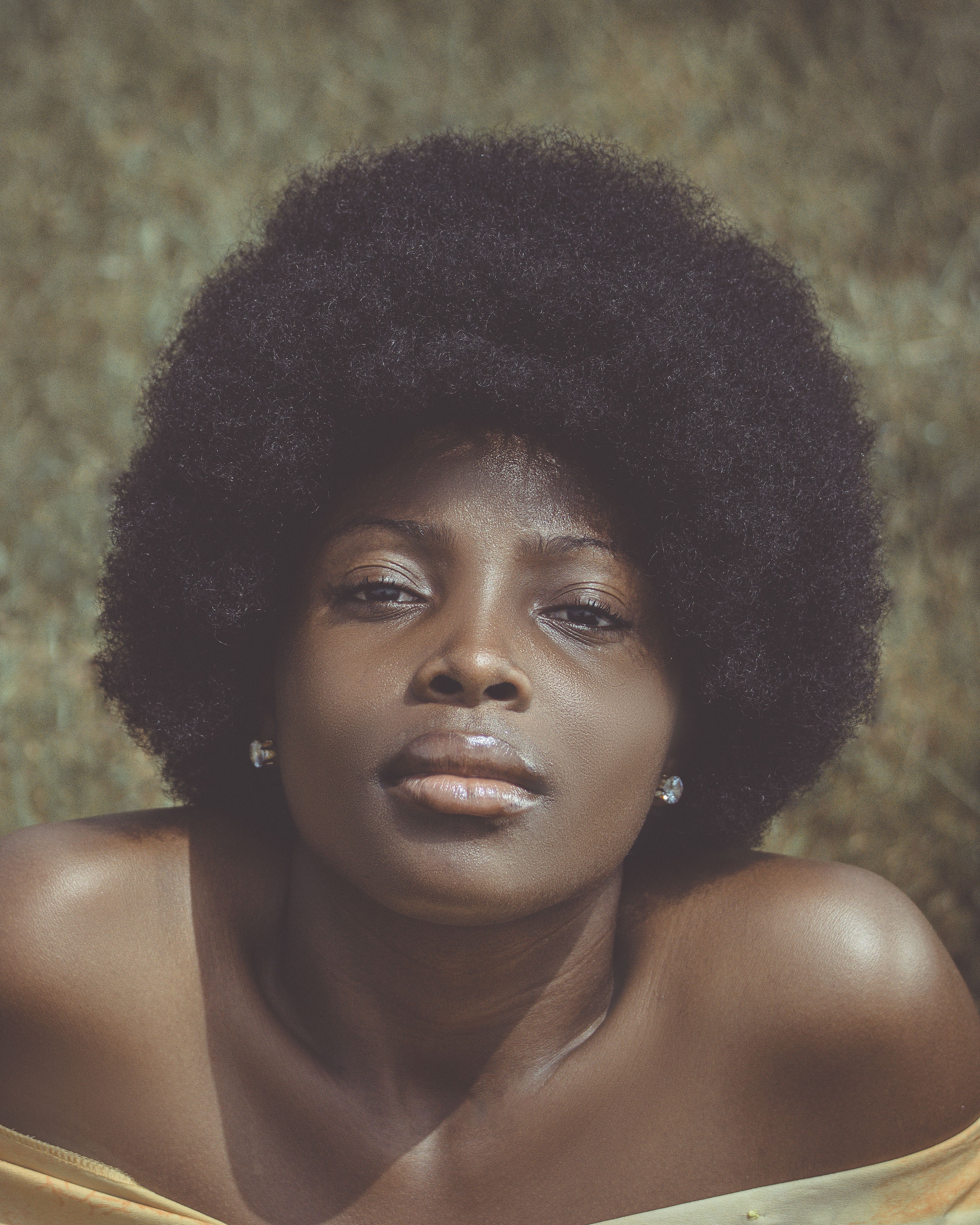 Close-up portrait of a beautiful woman with afro hairstyle in natural light.