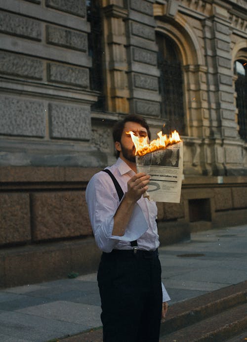 Free Man with Burning Newspaper Stock Photo