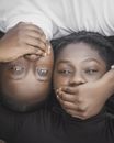 Man and Woman Lying Head to Head with Mouth Covered