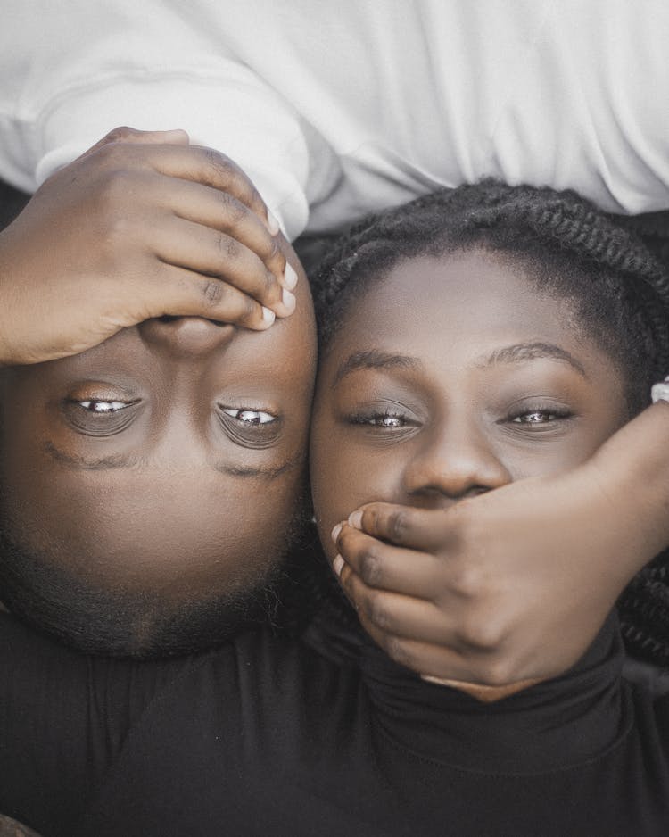 Man And Woman Lying Head To Head With Mouth Covered