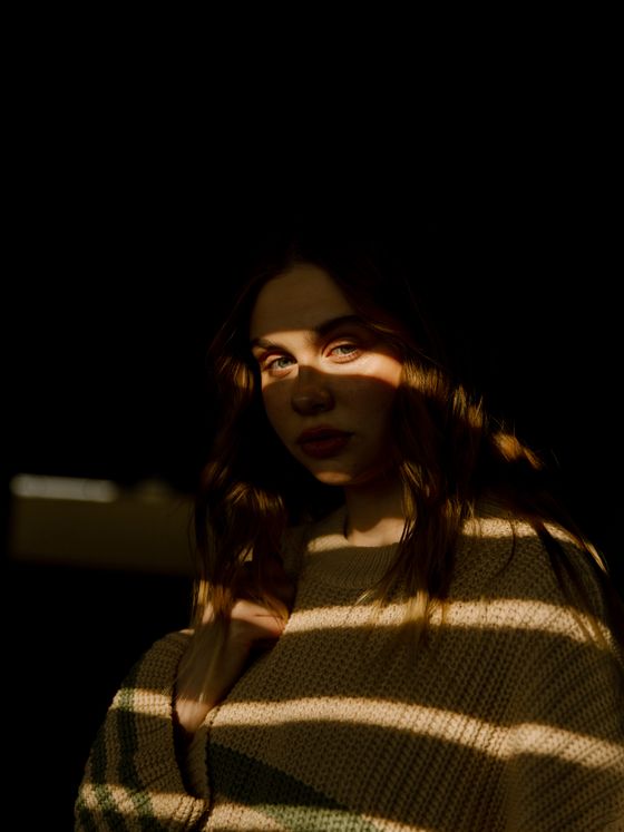 Striped knit lit by a single warm shaft, photo by Vladimir Gladkov on Pexels