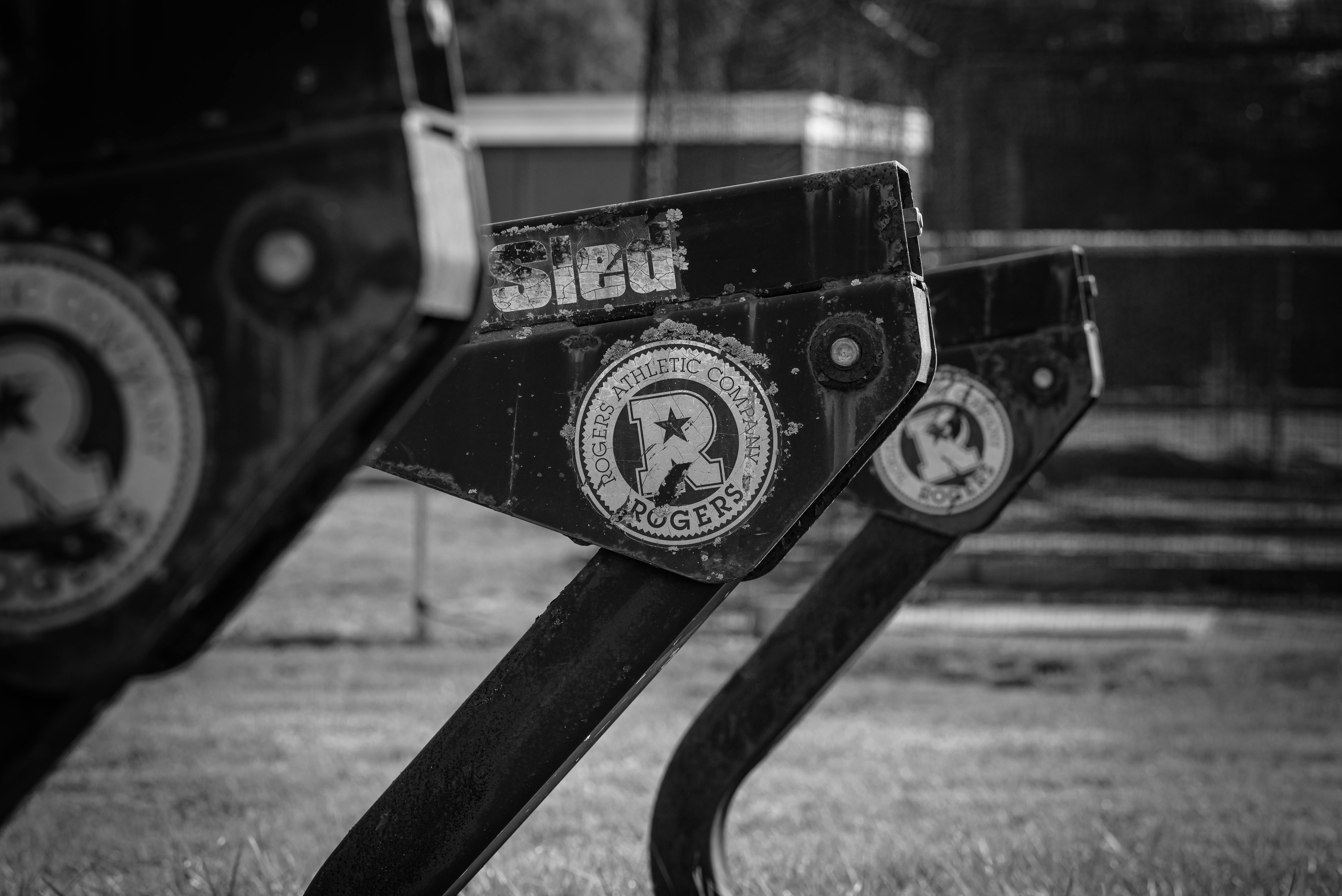 Monochrome image of Rogers Athletic Company sports sled equipment outdoors.