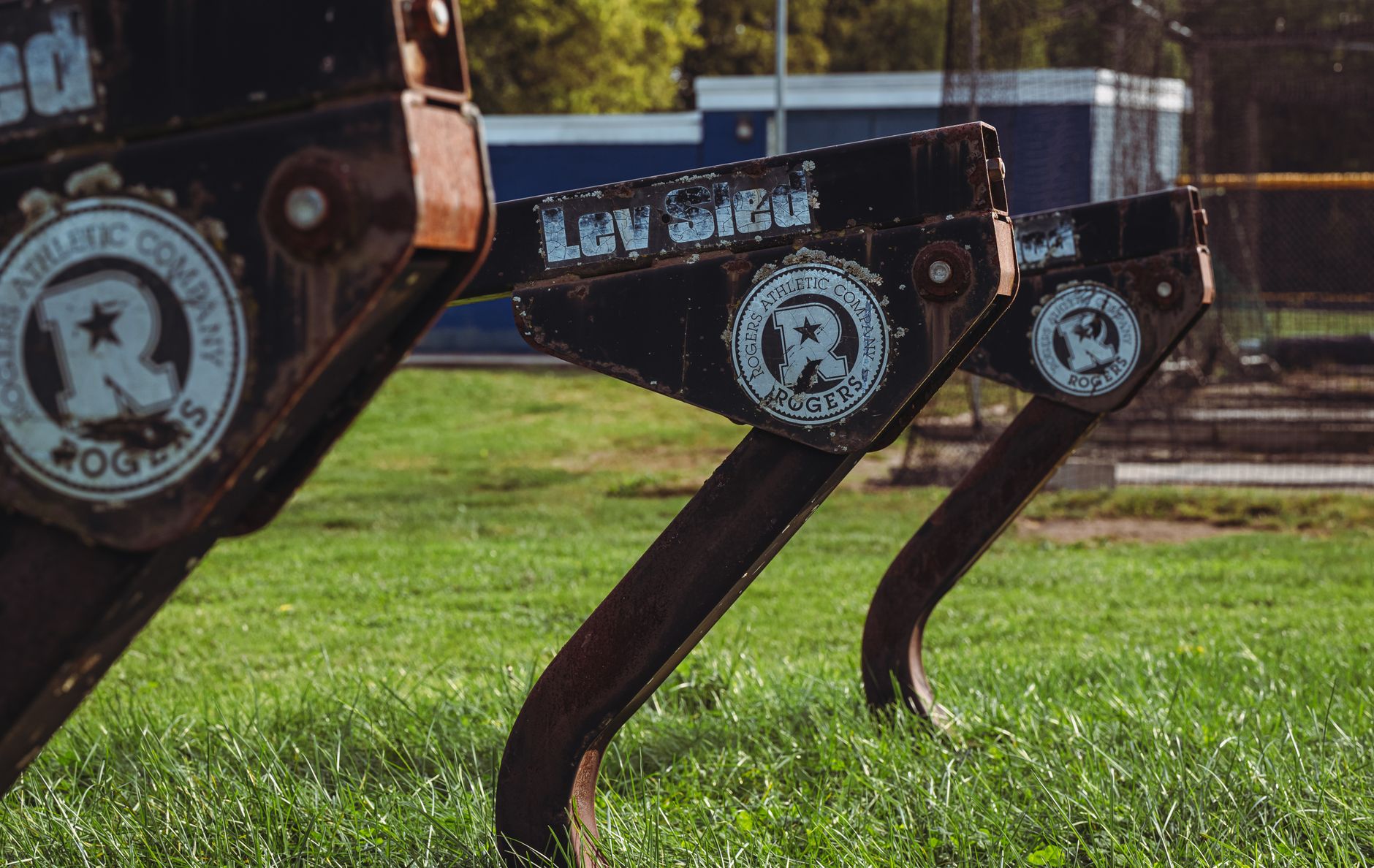 Close-up of vintage sleds on a football training field, capturing a sporty essence.