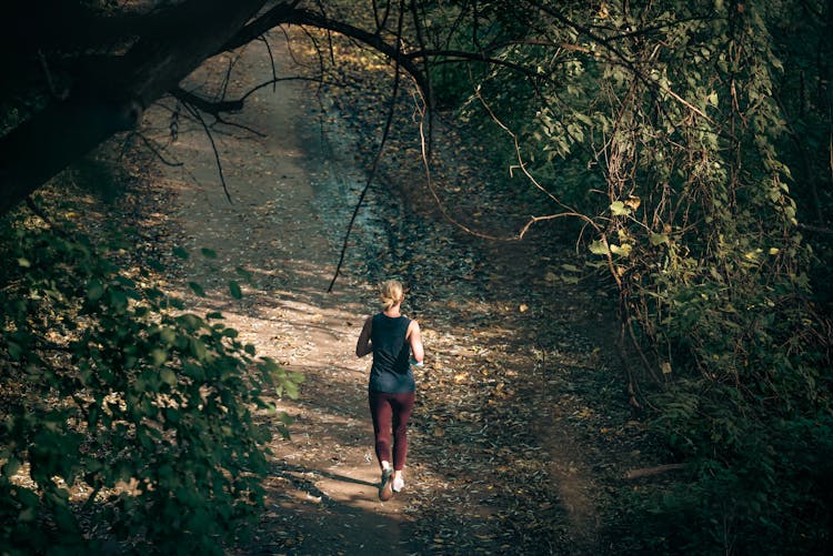 Woman In Black Tank Top Jogging On Dirt Road