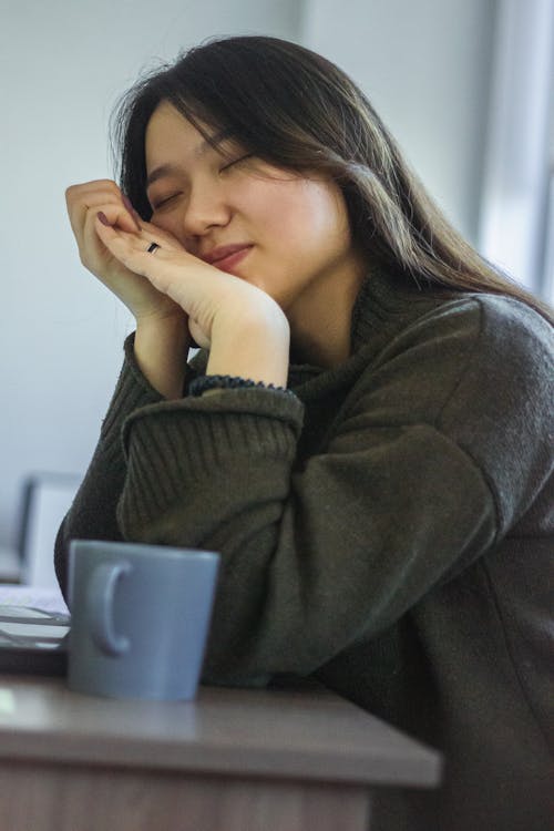 Woman in Gray Sweater Near Blue Ceramic Cup