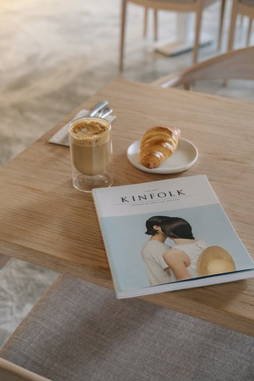Free Magazine, Coffee and Croissant on Table Stock Photo