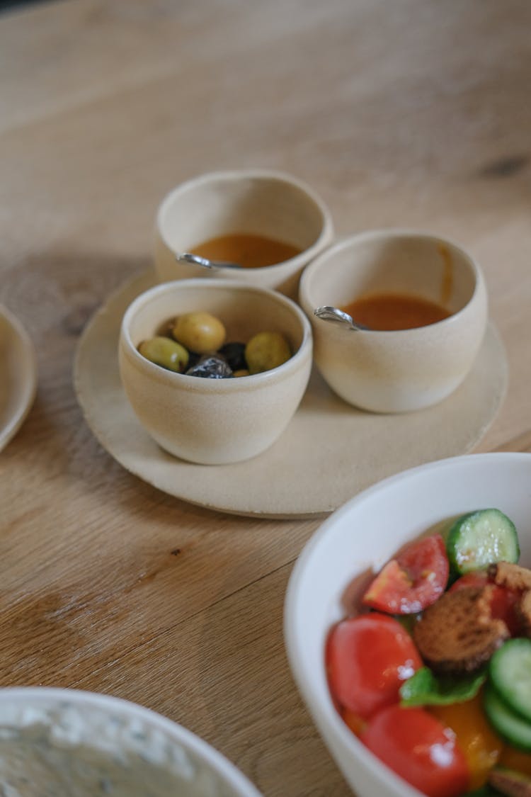 Small Bowls With Toppings Served On Plate With Bowl Of Salad