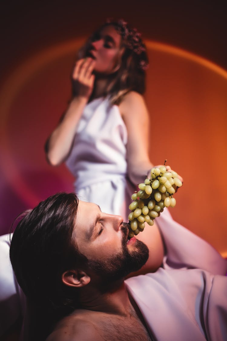 Selective Focus Photo Of Man Eating Green Grapes