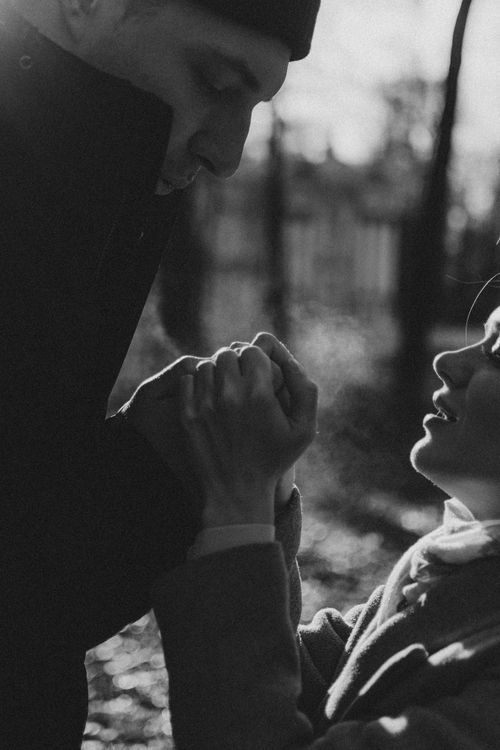Free Emotional black and white photo of a couple holding hands with love and warmth outdoors. Stock Photo