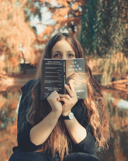 Woman hiding behind a Book 