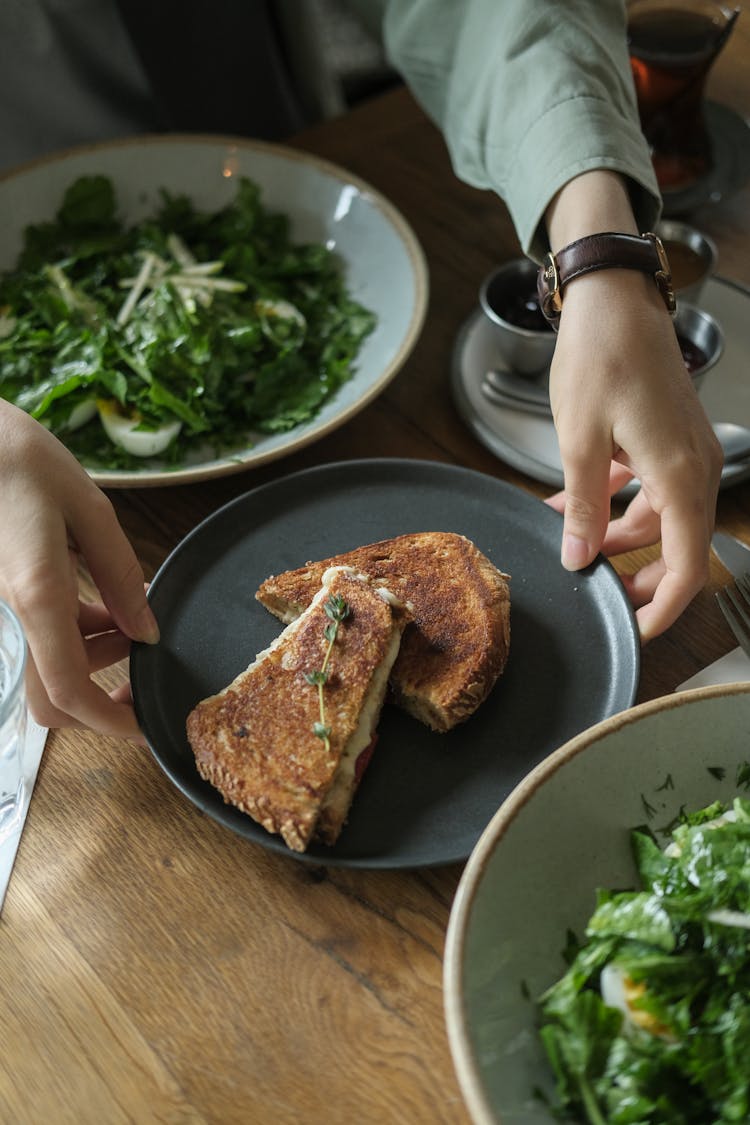 Hands Placing Plate Of French Toasts On Table