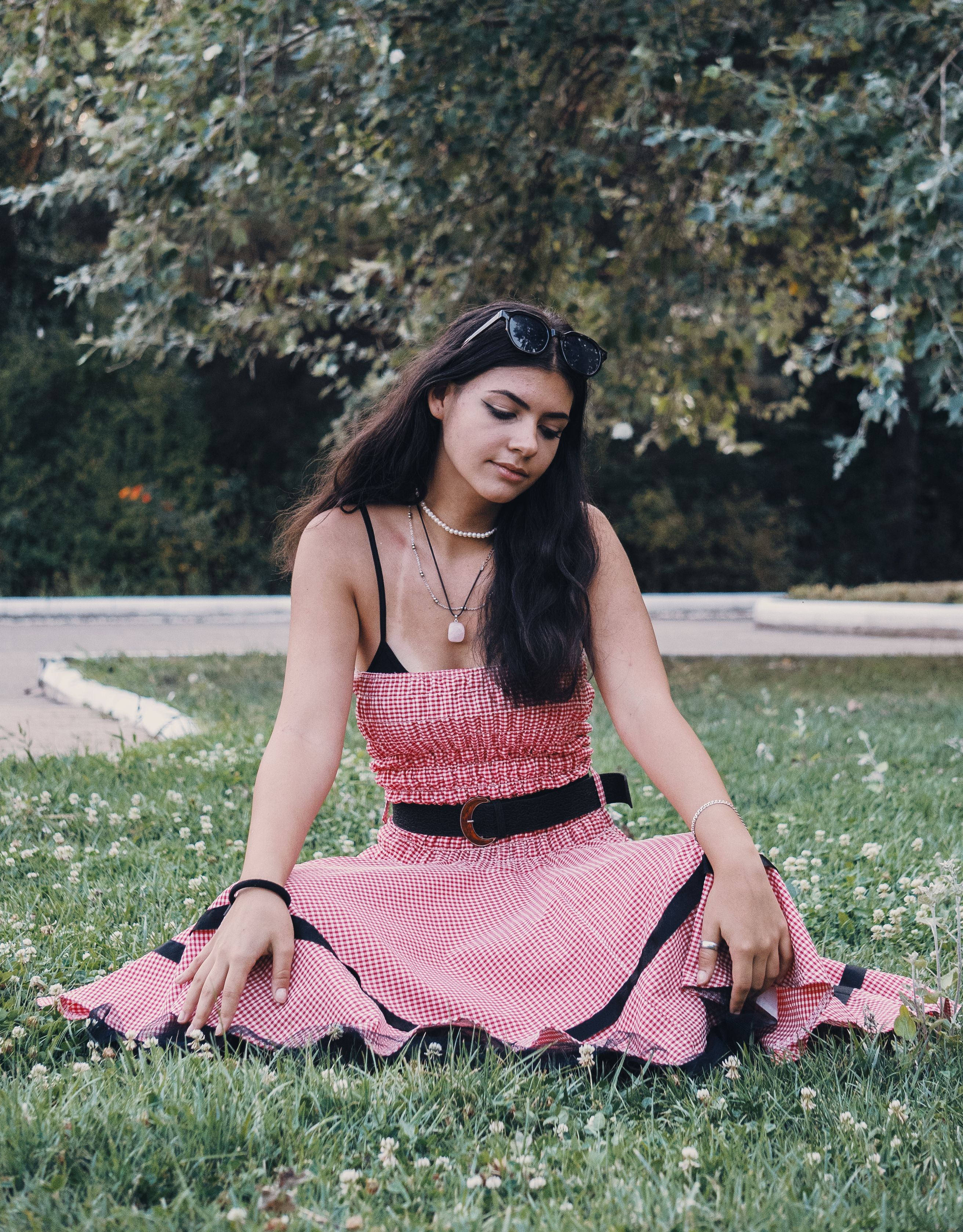 A Woman in a Striped Dress Sitting on Grass · Free Stock Photo