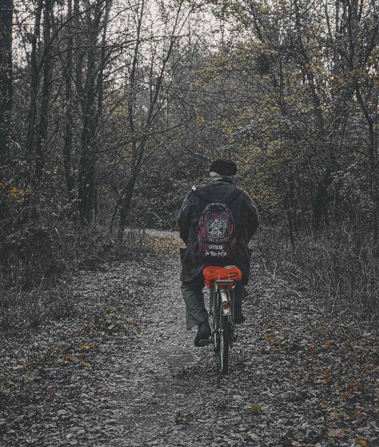 Elderly Man Cycling Through Woods