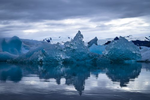 Free Captivating view of icebergs reflecting in calm waters in Iceland under a moody sky. Stock Photo