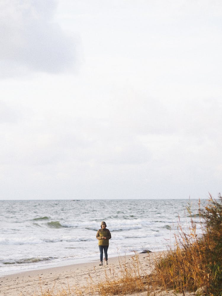 Person Walking Along Cold Beach